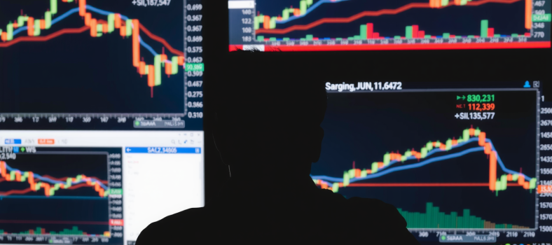 Analyst beobachtet Bildschirme mit Aktiencharts